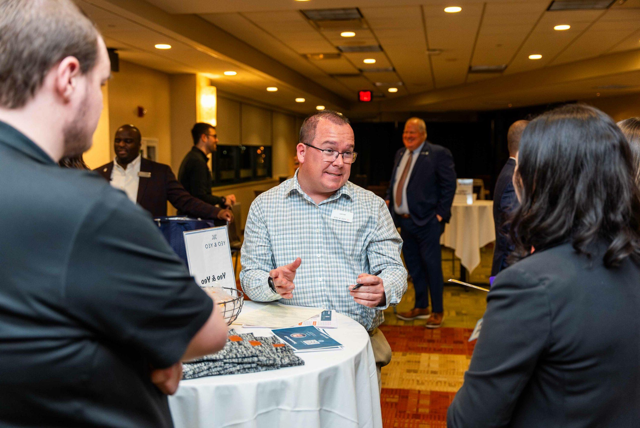 竞技宝app下载 students talking with an employer at the Networking Mixer